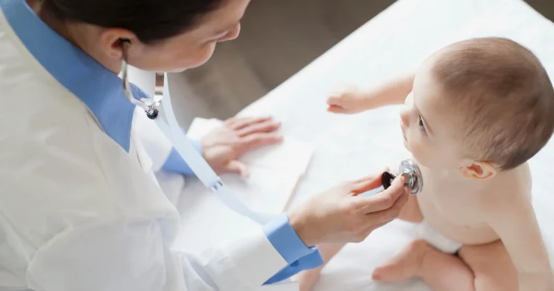 Doctor using stethoscope to hear the heartbeat of a baby