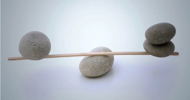 three stones and balance beam, one side with one stone and the other with two