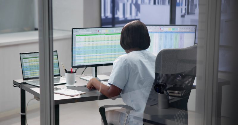 Healthcare worker coding on computer